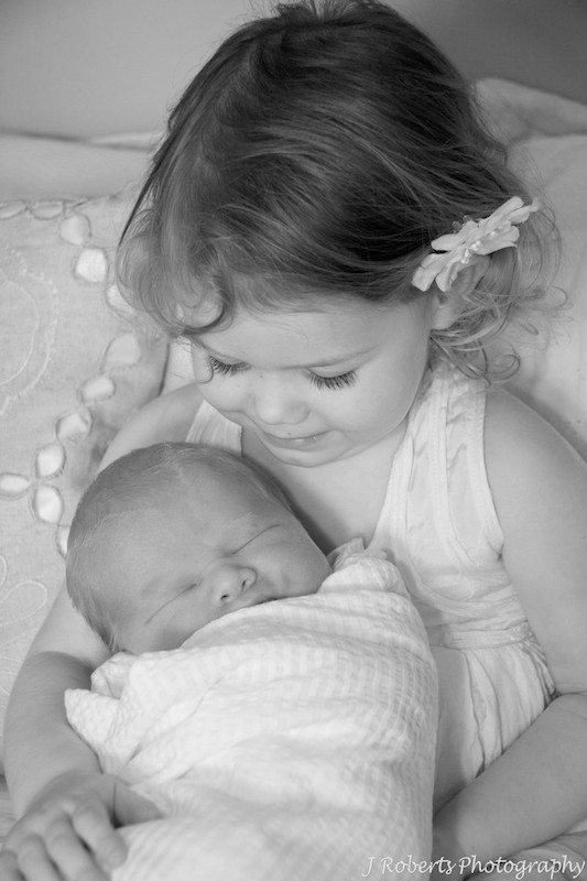 Big sister cuddling baby - newborn portrait photography
